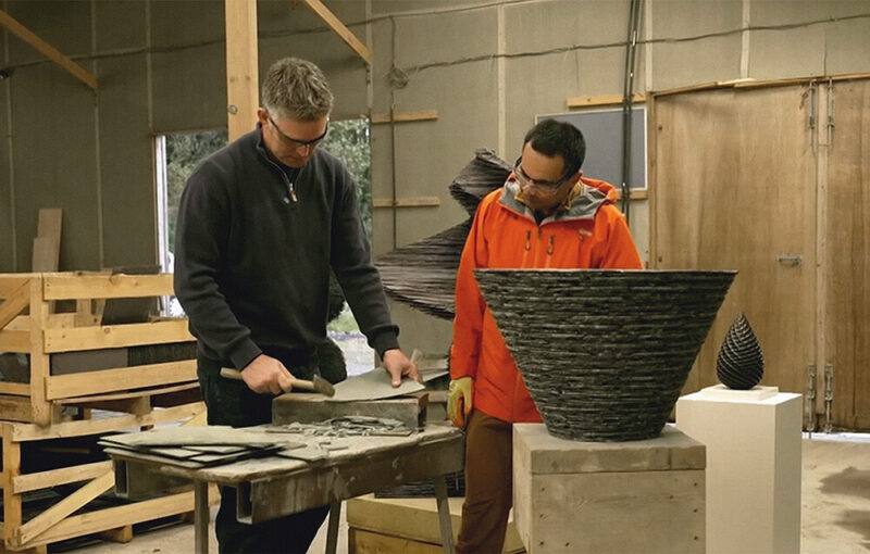 James Parker shaping slate in his Fife sculpture studio while demonstrating his process during filming for a television feature.