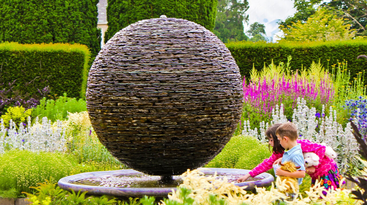 Monumental slate sphere water sculpture by James Parker installed in the gardens of Cawdor Castle, Scottish Highlands, within a publicly accessible historic landscape.