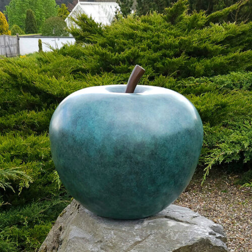 Limited edition bronze apple sculpture by James Parker, 90cm high, installed within a private garden in southern England.