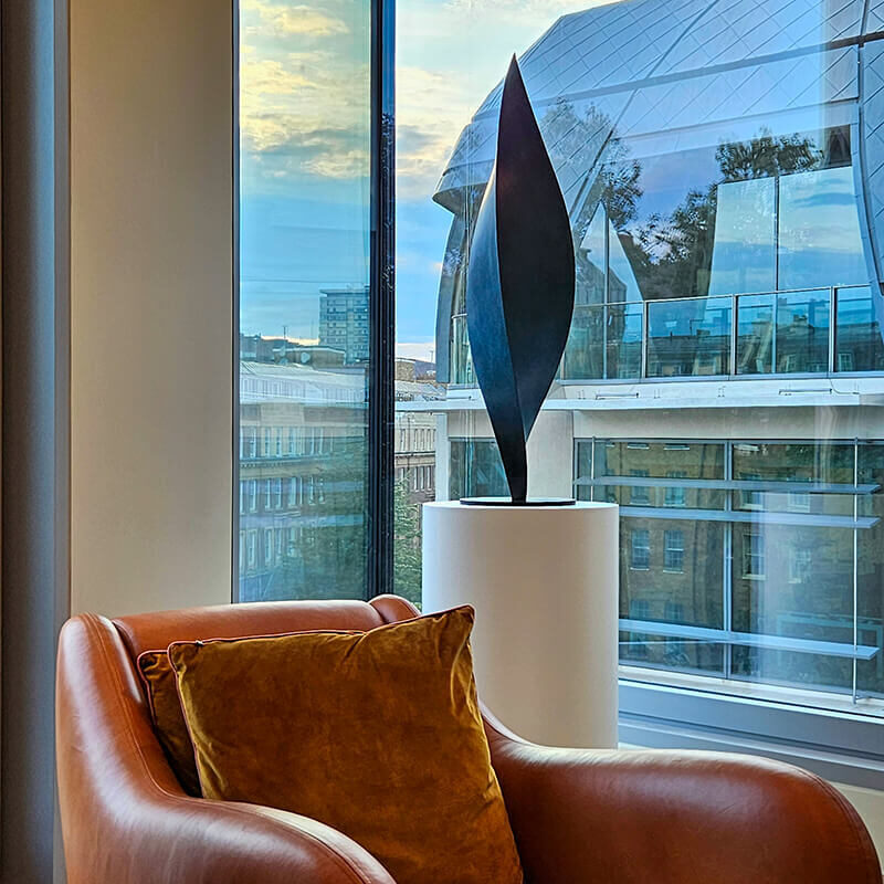 Limited edition bronze leaf sculpture by James Parker on a plinth in a contemporary London interior