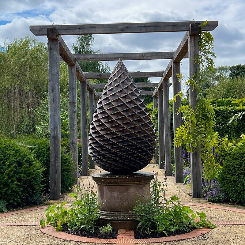 Limited edition bronze pine cone sculpture by James Parker inspired by Fibonacci geometry on a stone plinth
