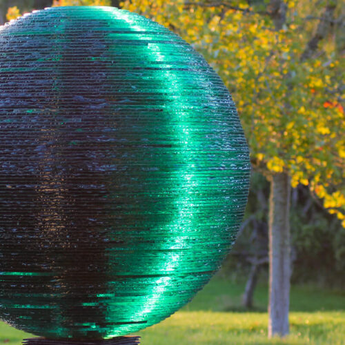 Detail of layered glass sphere in the monumental sculpture Light by James Parker, illuminated by low sunlight.