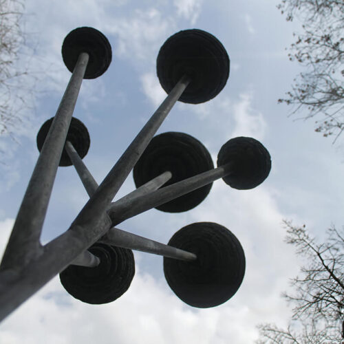 Cloud Tree slate sculpture by James Parker, featuring suspended stone spheres mounted on a steel structure against the sky.