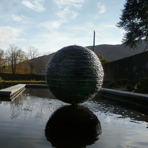 Slate sphere water sculpture by James Parker installed on the Ardnamurchan Peninsula, with water flowing over hand-stacked Ballachulish slate.