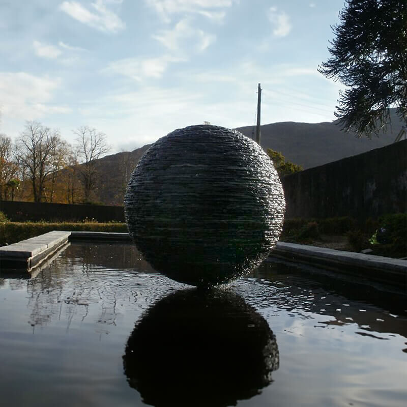 Slate sphere water sculpture by James Parker installed on the Ardnamurchan Peninsula, with water flowing over hand-stacked Ballachulish slate.