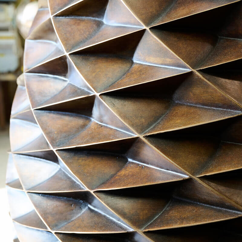 Close-up of geometric bronze surface showing precision casting and faceted modelling in a James Parker sculpture.