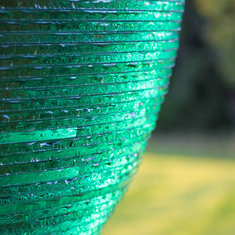 Close-up detail of layered stacked glass showing edge illumination and internal light diffusion.