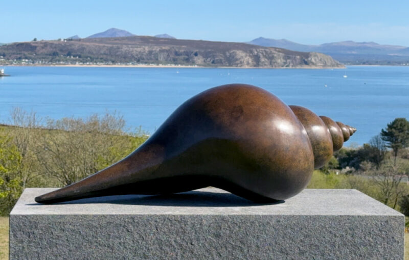 Bronze Shell sculpture overlooking the coast and mountains of North Wales