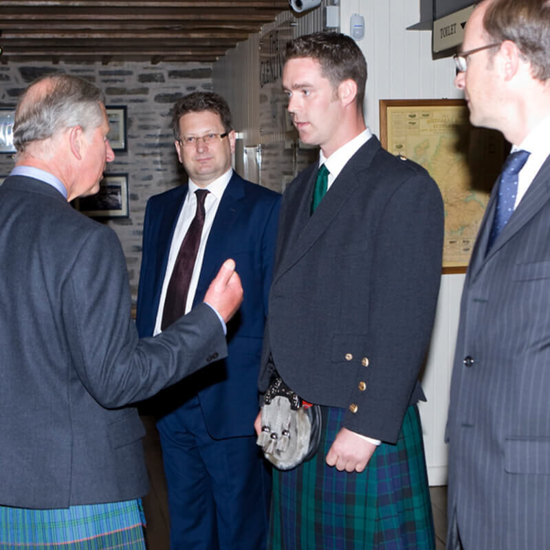 James Parker, Scottish sculptor, meeting Prince Charles at The Glenlivet Distillery. Both men are wearing kilts.